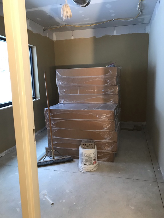 New Office with dark and light paint on walls along with ceiling tiles in boxes. Push broom too.