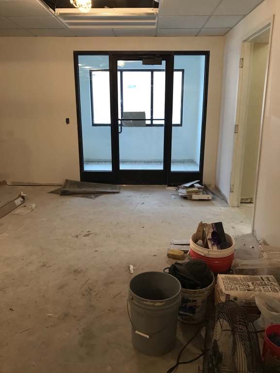 New entry door; light paint color on the walls and construction material on the floor.