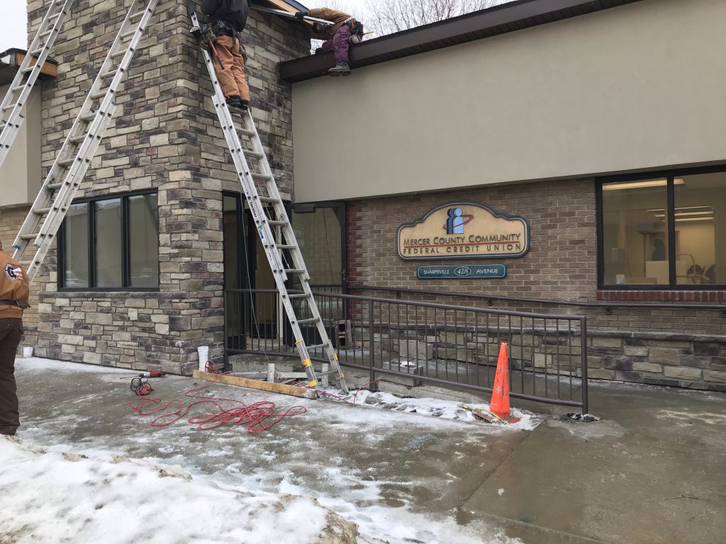 New entryway with workers on ladders 
