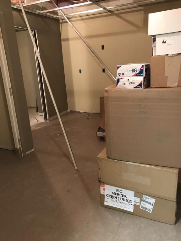 boxes of ceiling tile and paint on walls in employee break room